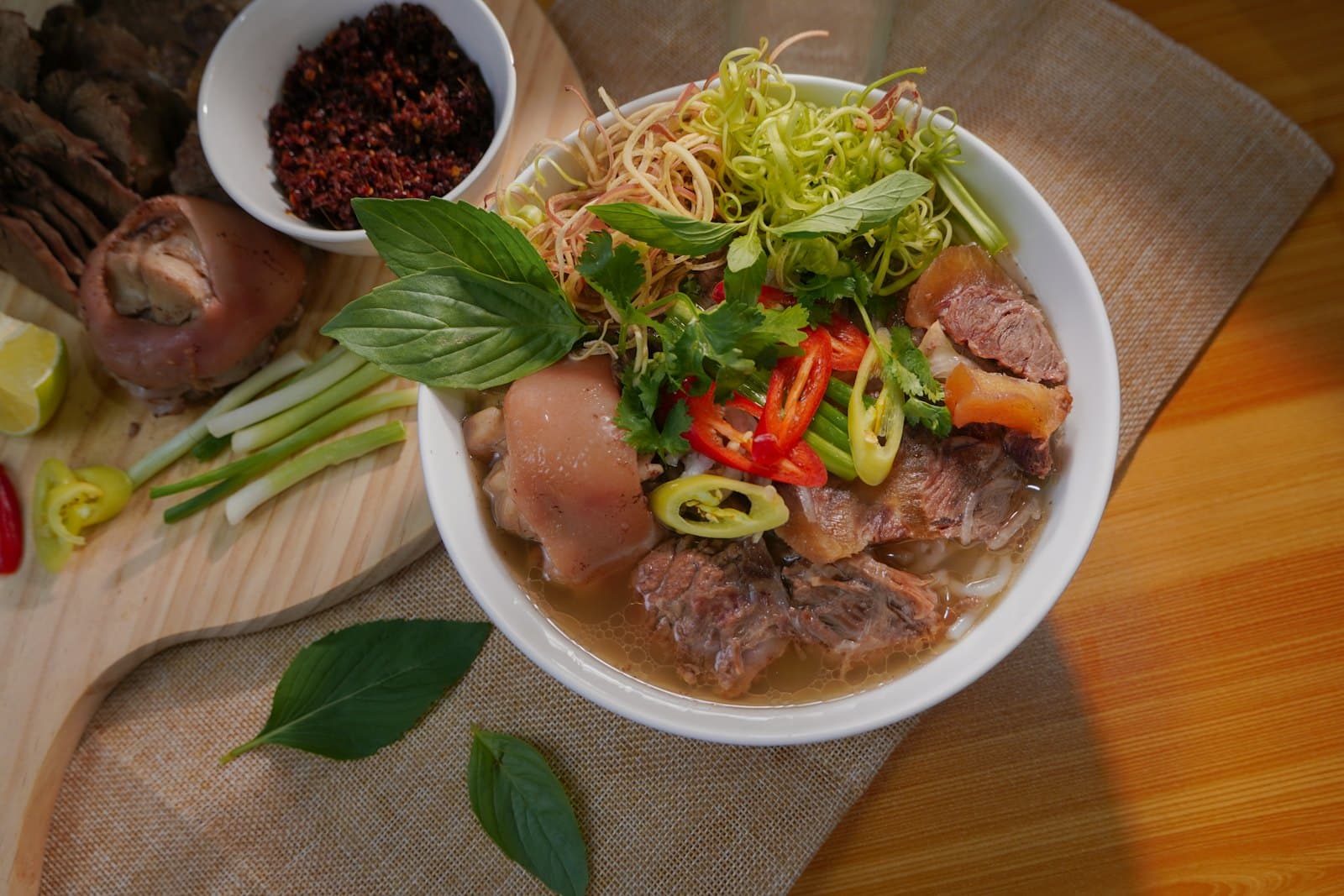 Dampfende Schale Phở mit Kräutern und Limette.
